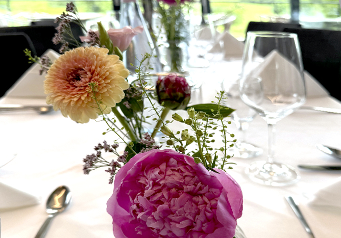 Ein Bild über einen gedeckten Tisch mit Blumenbouquet